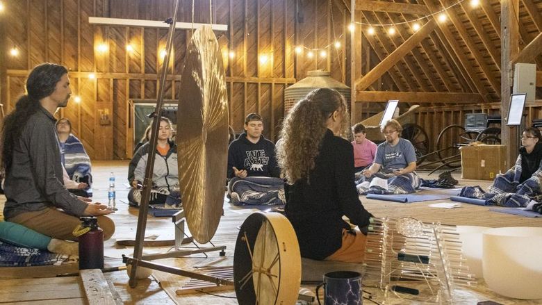 a group of students take part in sound meditation in the Fullers Overlook barn building