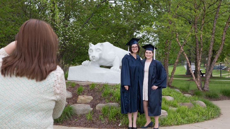 graduates posing at lion shrine