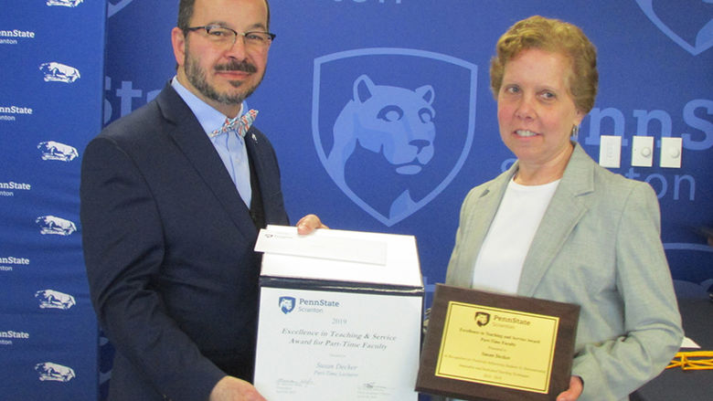 man in suit presents certificate to smiling woman