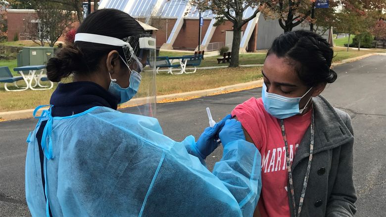 Campus nursing student prepares to give flu shot to student