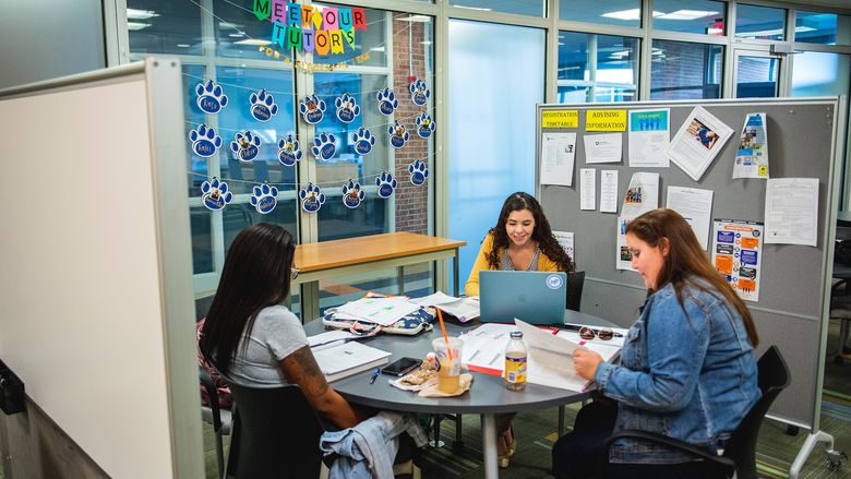 student tutors at table working in the learning center
