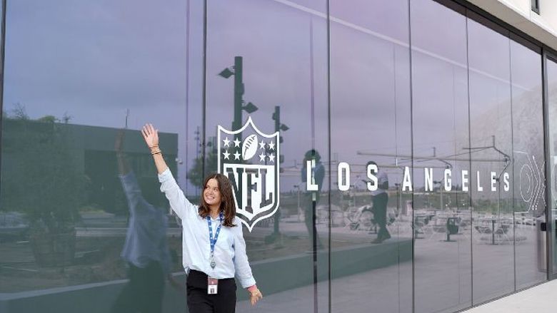 A student poses next to an NFL Los Angeles sign