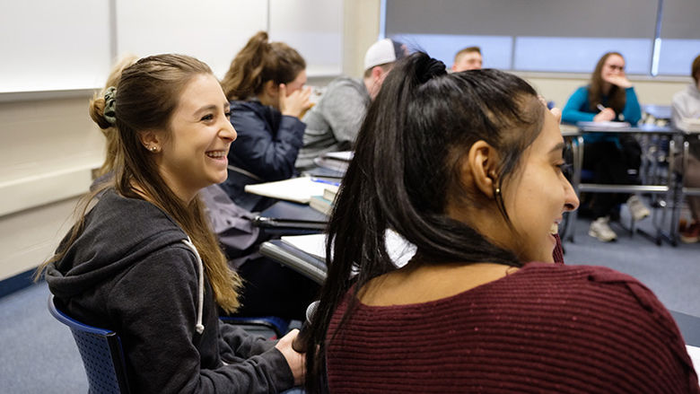 students sitting at desks and interacting in class