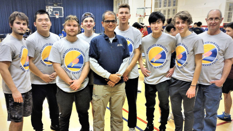 members of table tennis team posing for photo in gymnasium