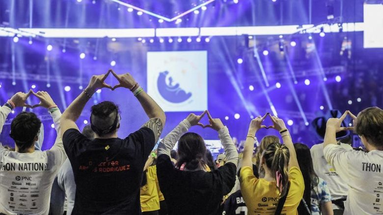 Scranton THON dancers face the stage and make the Four Diamonds symbol with their hands