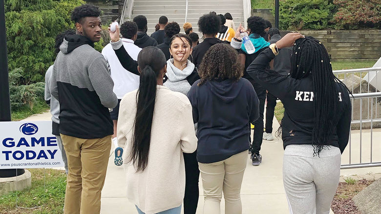 Group of students walking sidewalk at a University.