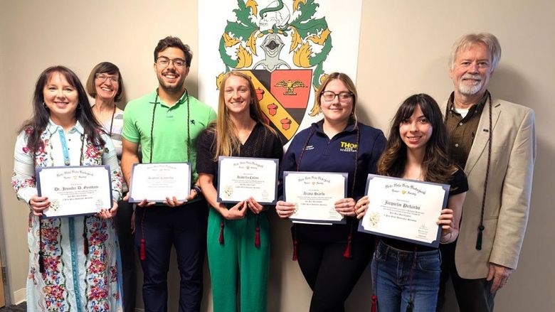 new beta beta beta inductees pose for a photo holding their membership certificates