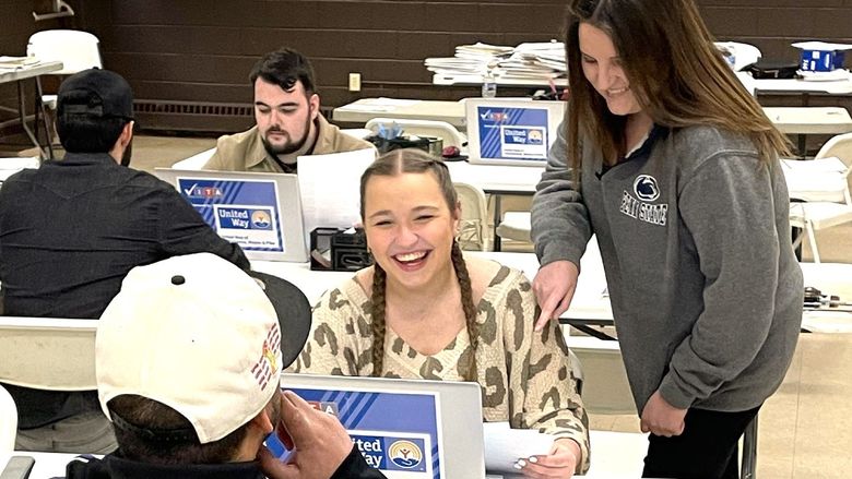 professor angela bassani assists a student during a volunteer session at VITA