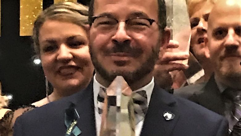 Chancellor Wafa holding Sage Award at ceremony