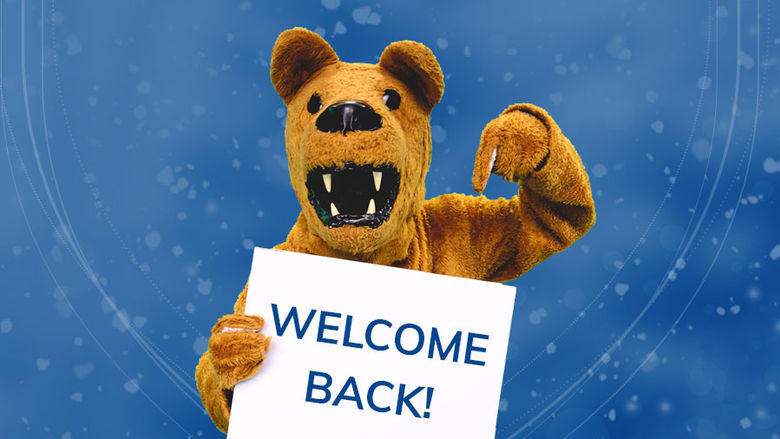 nittany lion mascot points at welcome back sign