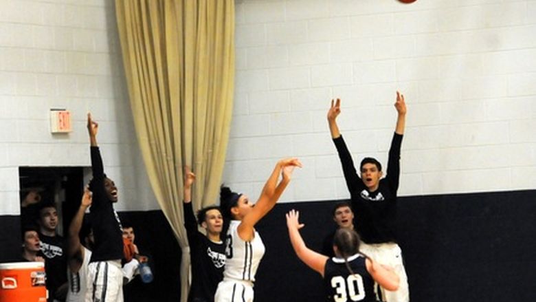Monique Hicks throwing basketball over York guard