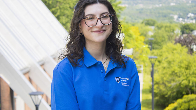 Student smiling with mountains in the background