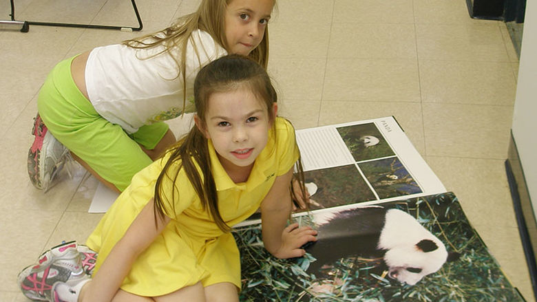 two girls look at images of panda bear