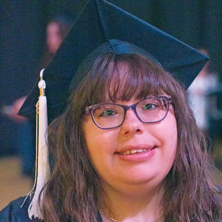 smiling Danielle Aiello in graduation cap and gown