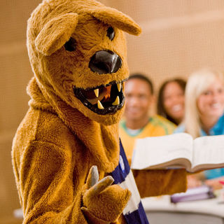 nittany lion mascot holding book in a classroom