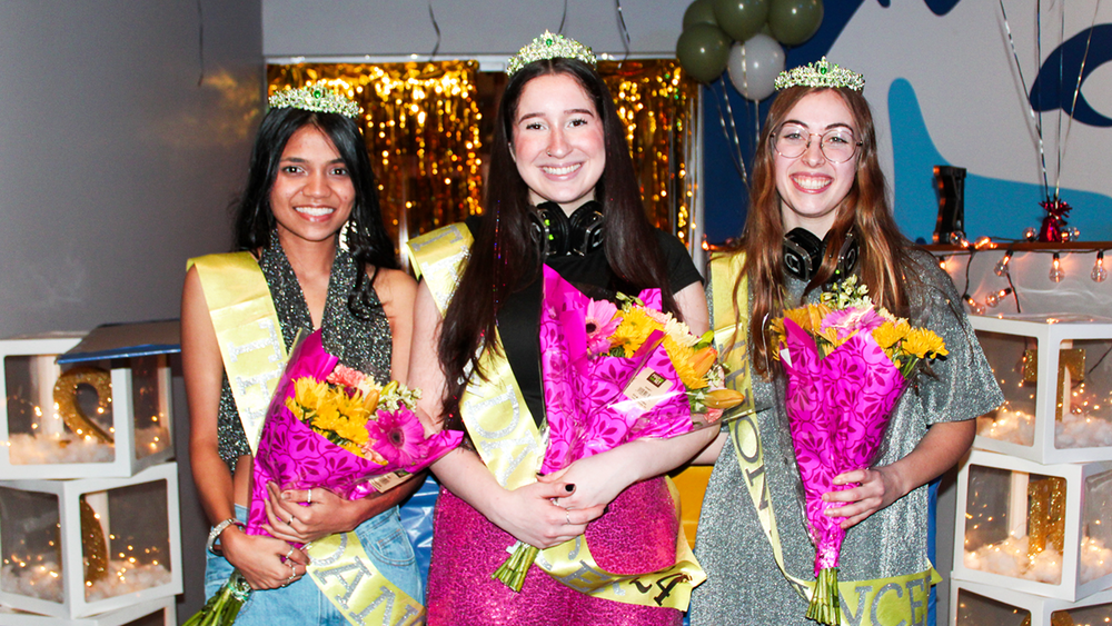 The three female students chosen as dancers pose for a photo at the reveal, holding flowers