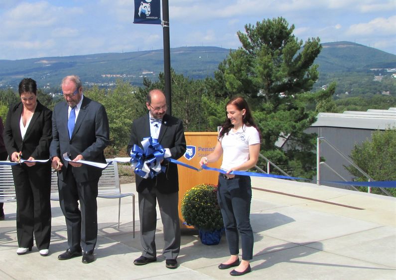 Several people cut a ribbon to dedicate the new Penn State Scranton patio