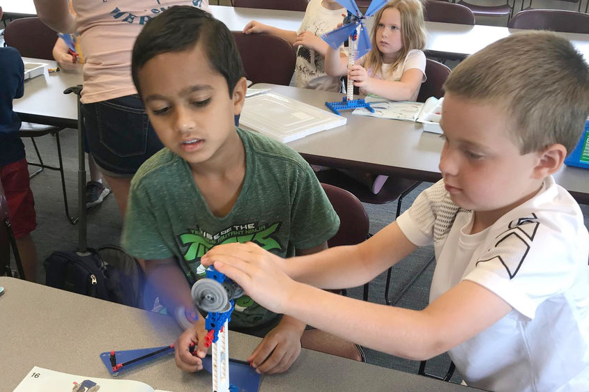 two young boys build windmill from Legos