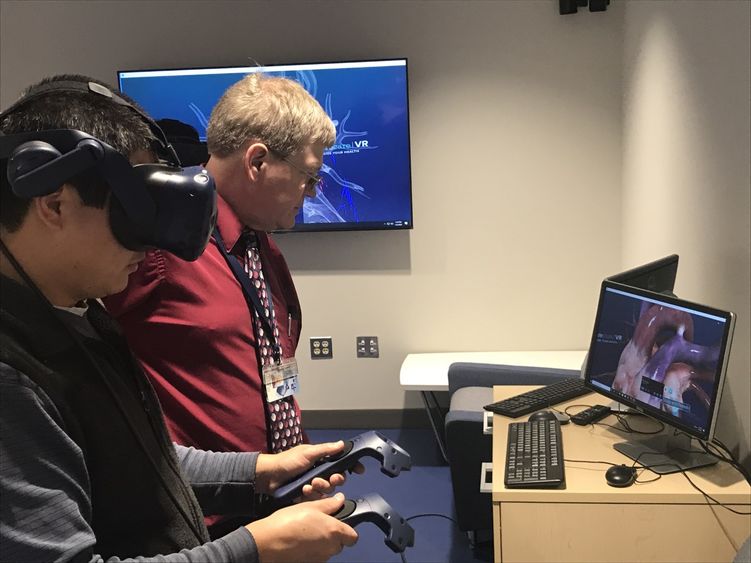 faculty members trying out virtual reality goggles and software