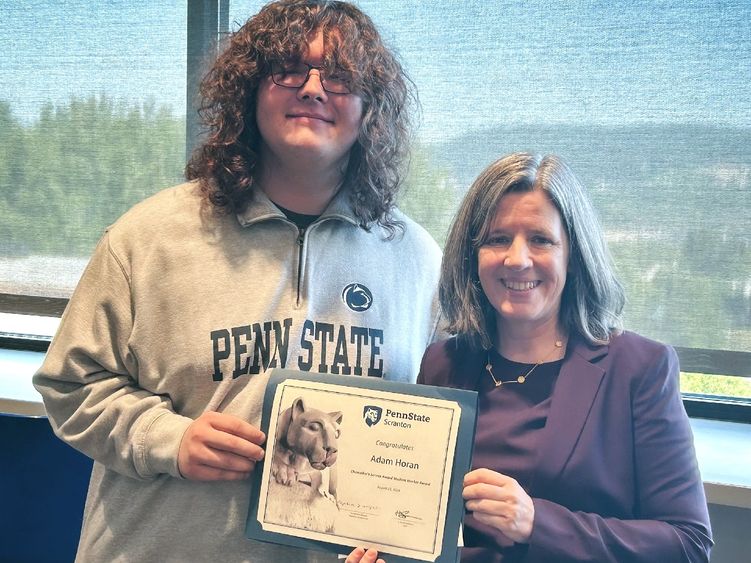 Student adam horan receiving certificate from chancellor liz wright