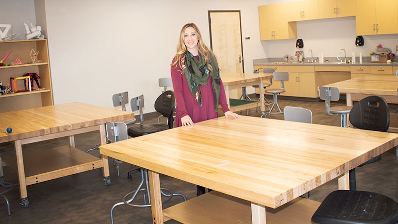 Lecturer in Art, Corianne Thompson stands near large art table in new Art Studio on Scranton Campus