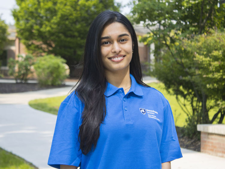 Student smiling wearing a shirt that says 'New Student Orientation' on it