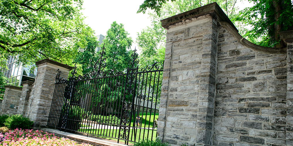 Photograph of the gates to campus from Allen Street