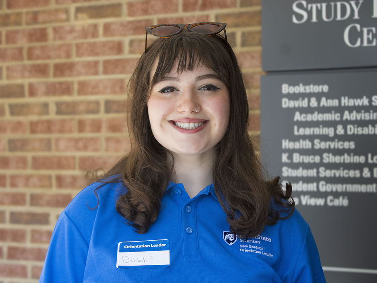 Student smiling stands in front of building that reads 'Study Learning Center'