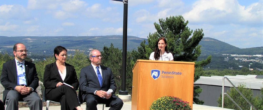 emily scarfo at podium at patio  dedication speaking