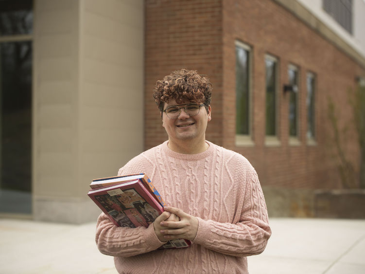 photo of Grant Loose in front of library building holding a padfolio