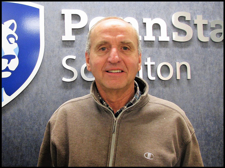 headshot of Jake Hinton standing in front of Penn State Scranton wall