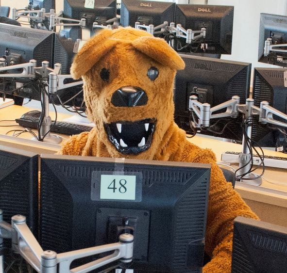 nittany lion mascot seated at computer in campus computer lab