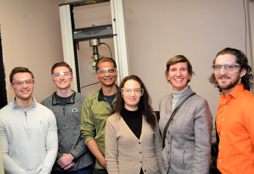 Lockheed martin group pose for a photo with equipment they used in experiment