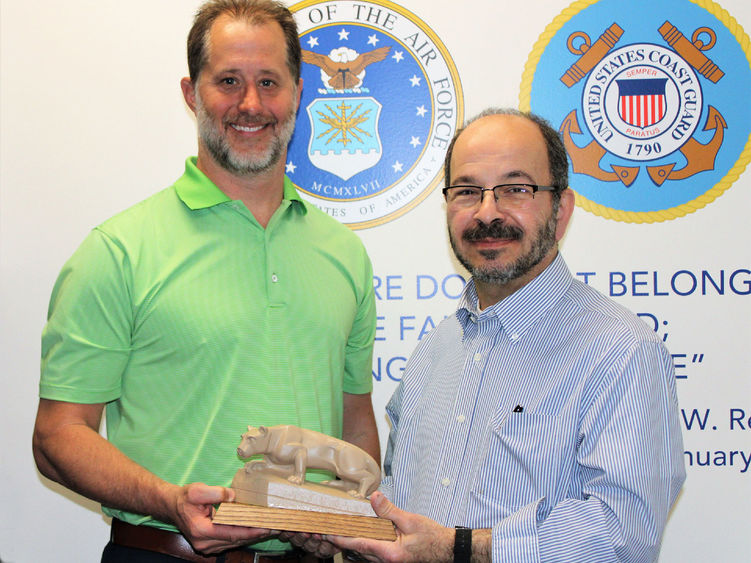 Campus alumnus EJ Long, at left, receives a Nittany Lion Shrine statue from campus Chancellor Marwan Wafa during a tour of the newly created Veterans Lounge he donated to.