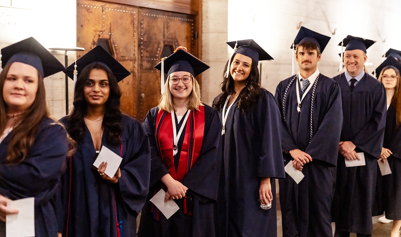 group of grads in cap and gown smiling
