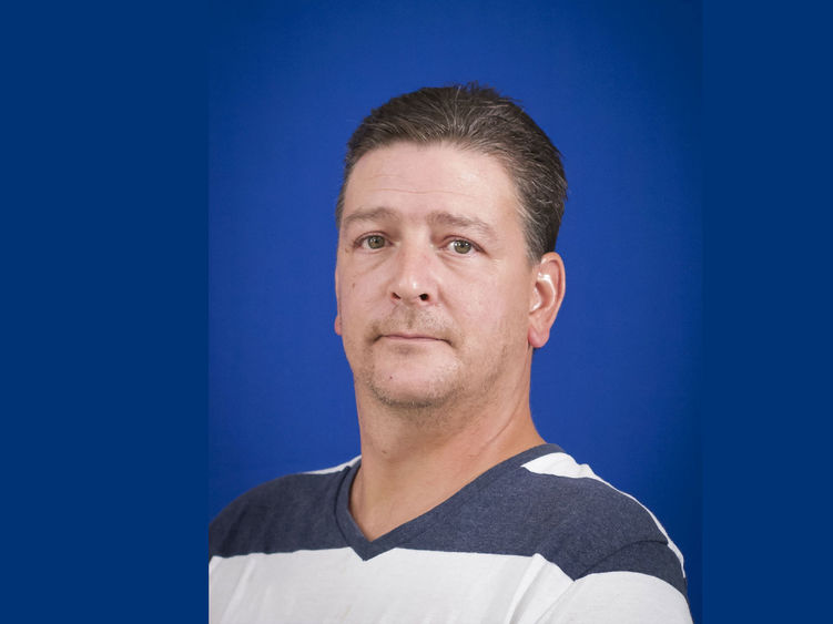 headshot of Wayne Reesey wearing blue and white striped shirt