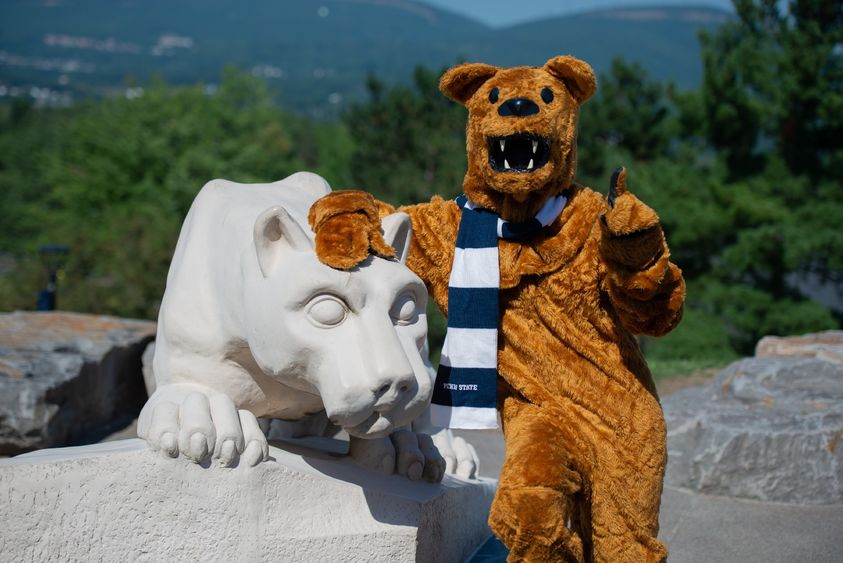 nittany lion mascot posing for photo at nittany lion shrine, pointing toward camera