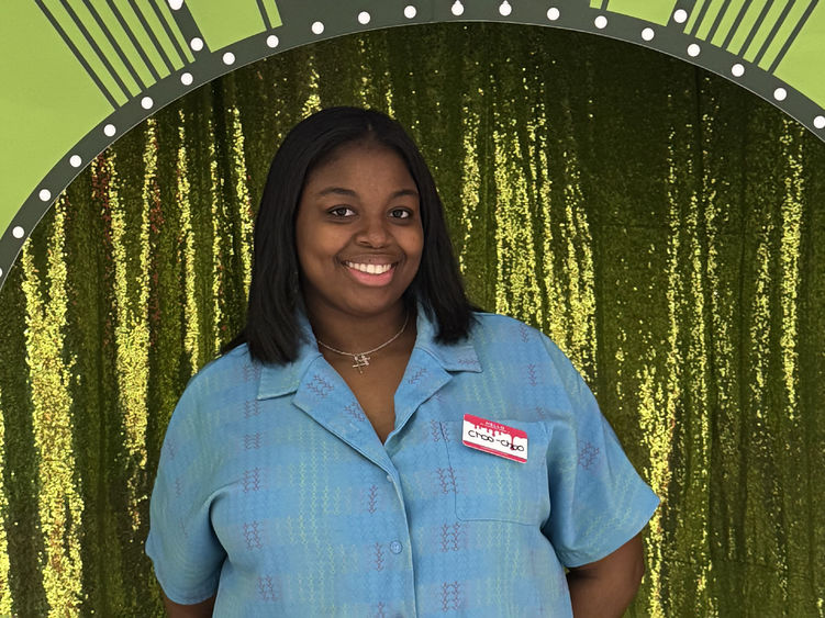 Charrise Lamothe poses for a photo in front of a green curtain
