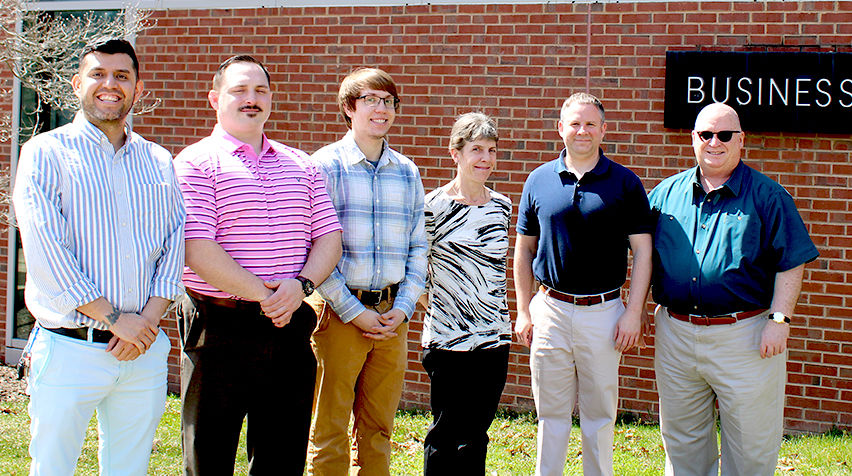 scranton business club members pose for a photo in front of business building