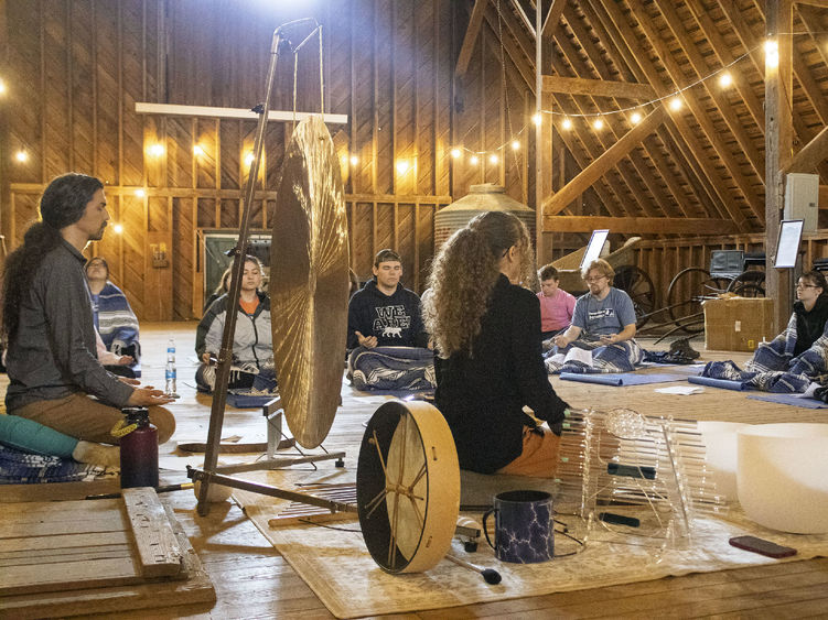 a group of students take part in sound meditation in the Fullers Overlook barn building