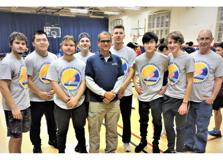 members of table tennis team posing for photo in gymnasium